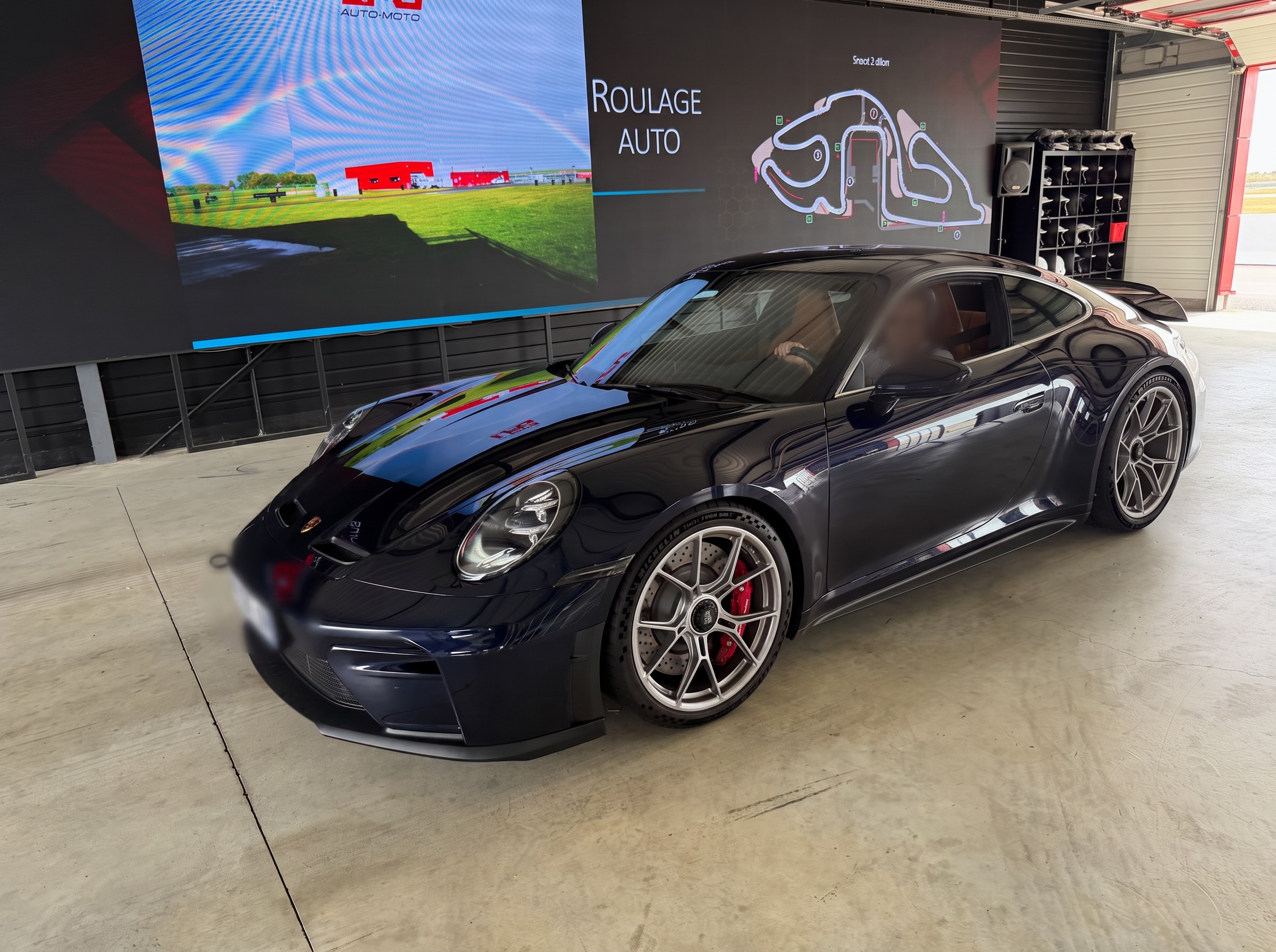 Porsche 992.2 GT3 Touring bleu nuit, trois quarts avant, dans les stands