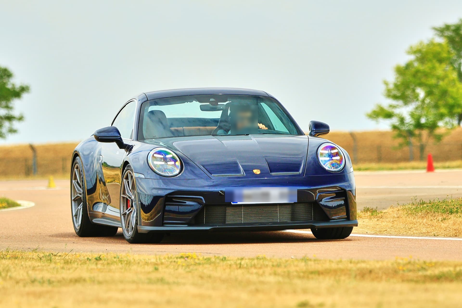 Porsche 992.2 GT3 Touring de face sur circuit, en pleine accélération