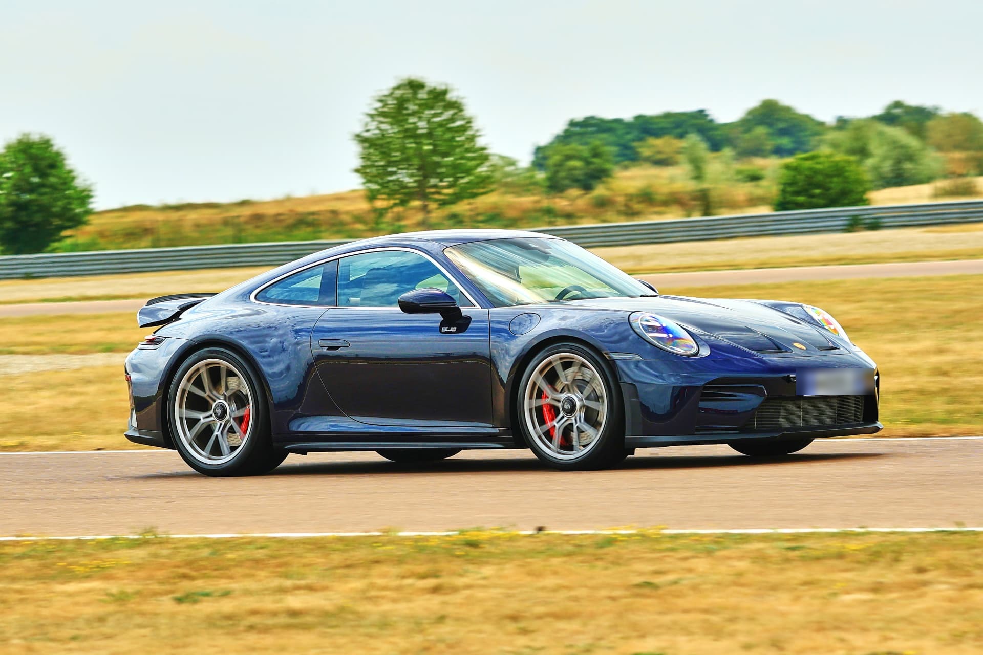 Porsche 992.2 GT3 Touring de profil en vitesse sur circuit