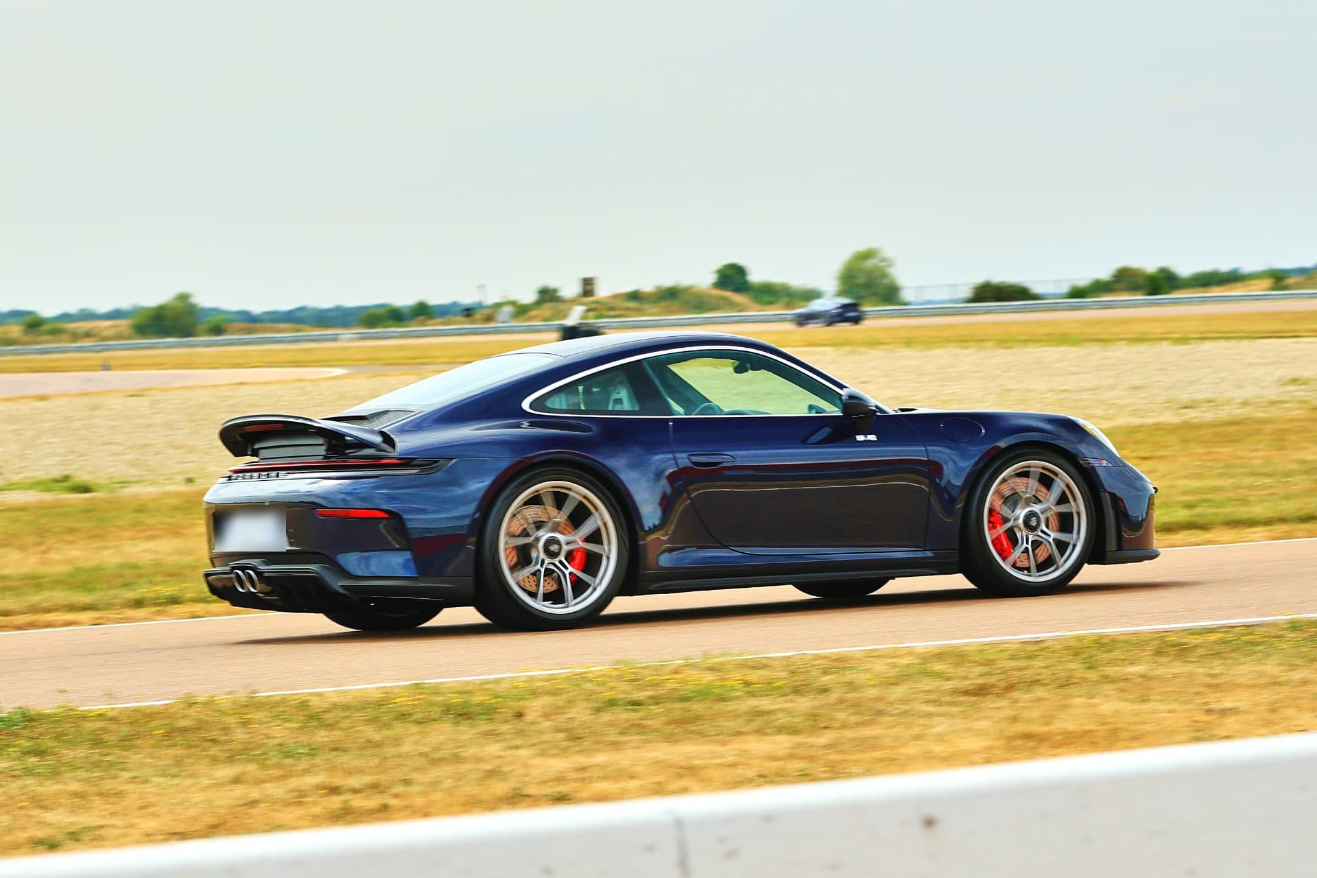 Porsche 992.2 GT3 Touring de trois quarts arrière, becquet déployé sur circuit